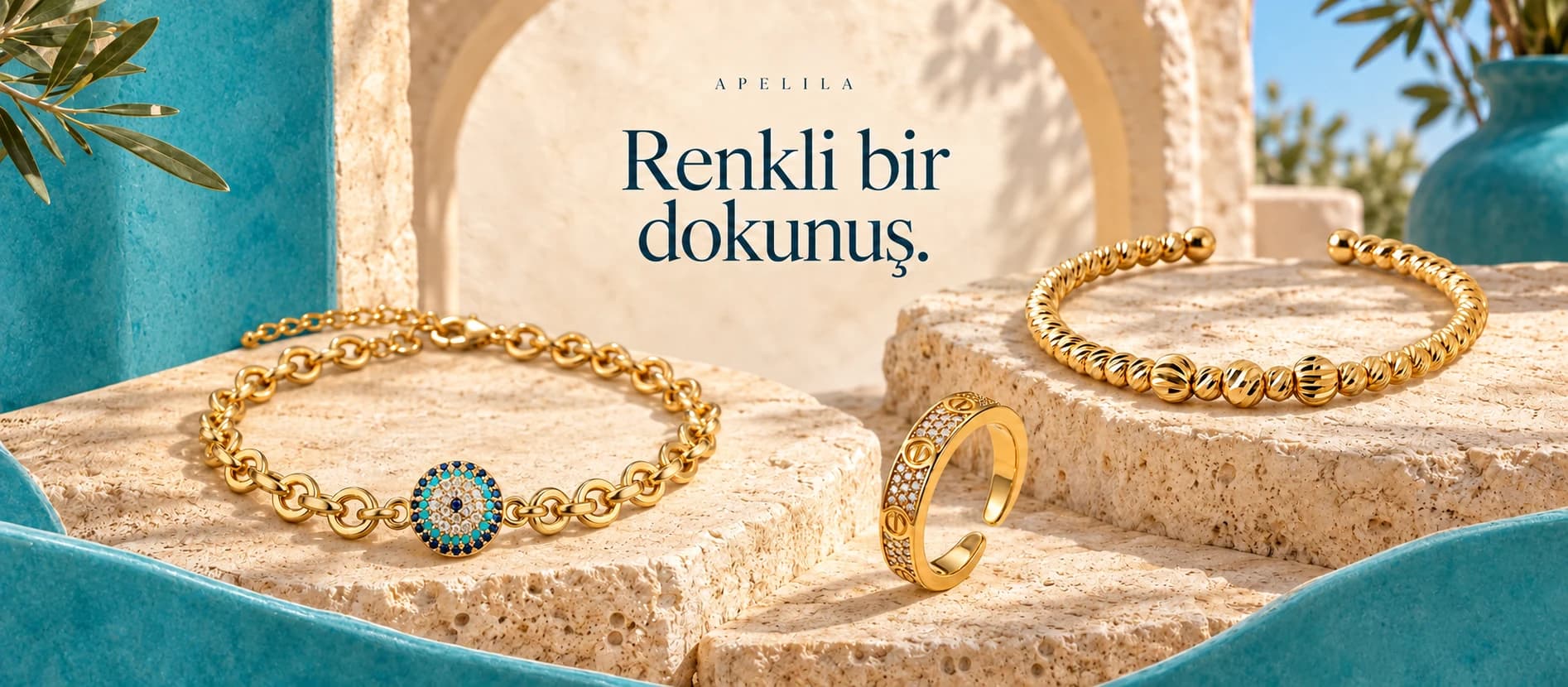 Renkli bir dokunuş. Turkuaz sahnede nazar motifli zincir bileklik, Dorika bileklik ve taşlı açık yüzük.